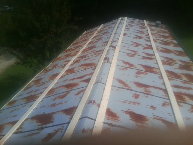 Rusted metal roof panels with new wood purlins before replacement — Storm Damage Roof Repair in Vining by Roofing Brothers